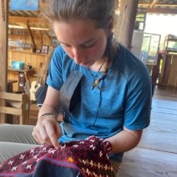 Stitching jobs tears (seeds) onto a traditional Karen blouse